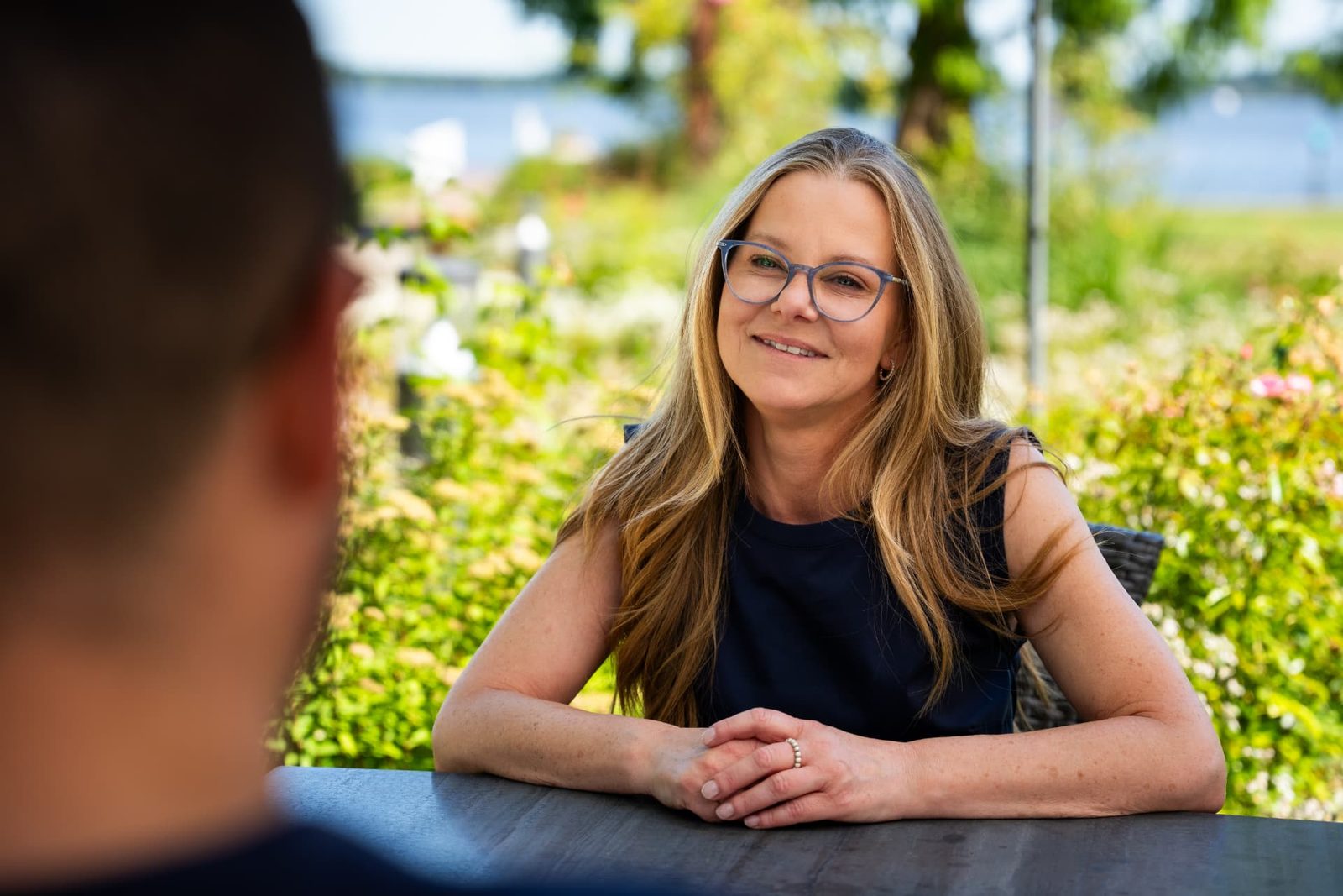 Stephanie Neiß im persönlichen Gespräch an einem Tisch im Grünen
